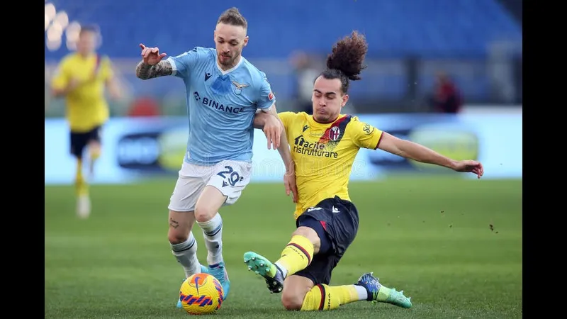 Cầu thủ Lazio dùng kỹ thuật cá nhân vượt qua hậu vệ Bologna trên sân cỏ Cầu thủ Lazio dùng kỹ thuật cá nhân vượt qua hậu vệ Bologna trên sân cỏ