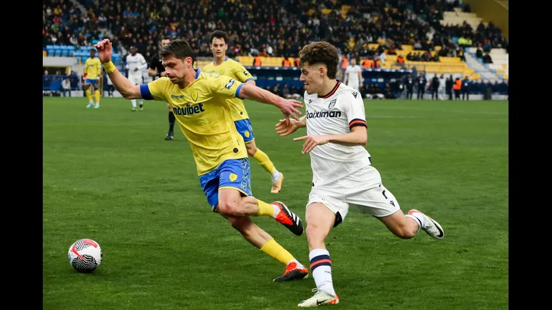 Cầu thủ Panserraikos tập trung chuyền bóng trước áp lực từ hậu vệ Panetolikos Cầu thủ Panserraikos tập trung chuyền bóng trước áp lực từ hậu vệ Panetolikos