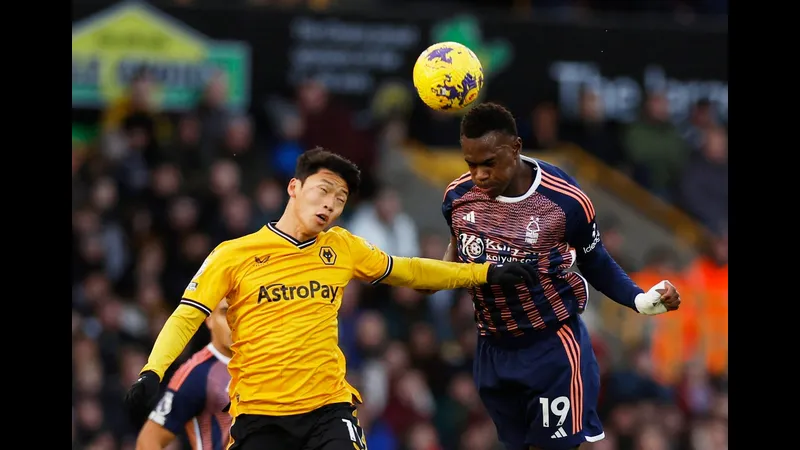 Cầu thủ Wolves với màu áo màu đỏ đang cố gắng cản phá một cầu thủ Nottingham Forest đang đi bóng. Cầu thủ Wolves với màu áo màu đỏ đang cố gắng cản phá một cầu thủ Nottingham Forest đang…